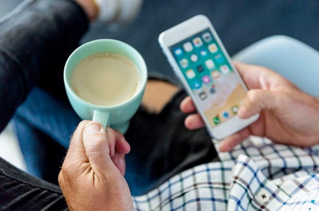 Hombre con celular y cafe